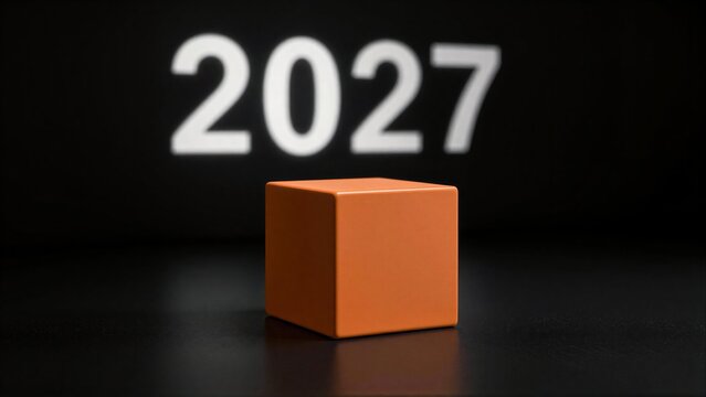 Orange cube on dark surface, glowing 2027 projected behind it.