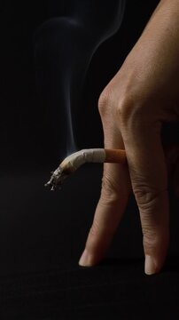 Bent cigarette between fingers symbolizing erectile dysfunction