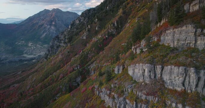 Soaring Alongside Autumn Rocky Mountain Side At Dusk - Wide Shot
