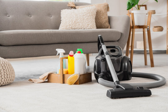 House cleaning and home maintenance, vacuum cleaner with supplies and detergent bottles on carpet in living room for spring cleaning and chores