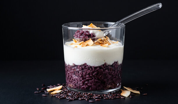 Sua Chua Nep Cam (Black Sticky Rice Yogurt): A dessert glass layered with dark purple fermented black sticky rice and thick white creamy coconut yogurt,