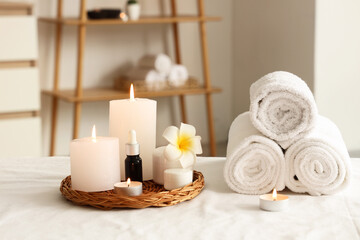 Naklejka na ściany i meble Wellness and spa relaxation, candles with essential oil and rolled towels on massage table for holistic health and beauty treatment in therapy room