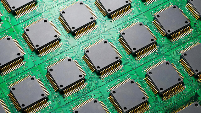 Multiple identical integrated circuit chips with gold pins are arranged on green printed circuit boards, used in electronic manufacturing.