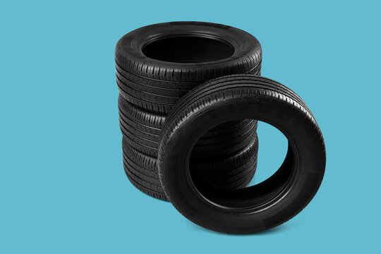 Automotive maintenance and tire replacement, stack of new black rubber car tires for vehicle safety and transportation service on a blue background
