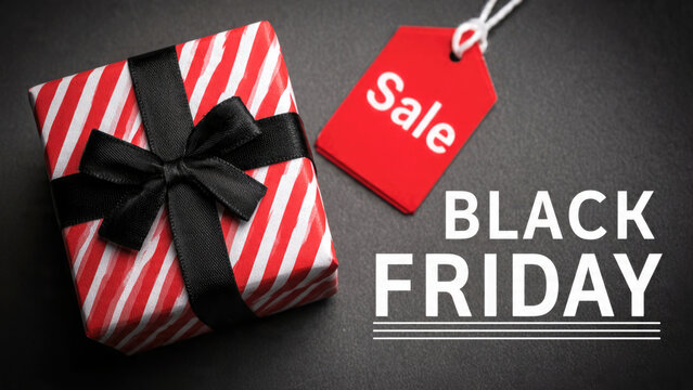 Gift box with red sale tag and black friday text on dark background