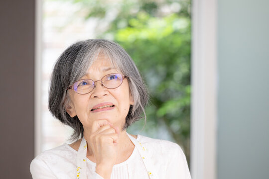 日本人の高齢女性、健康寿命、アクティブシニア、老後の暮らし、困る考える悩むポーズで見上げる