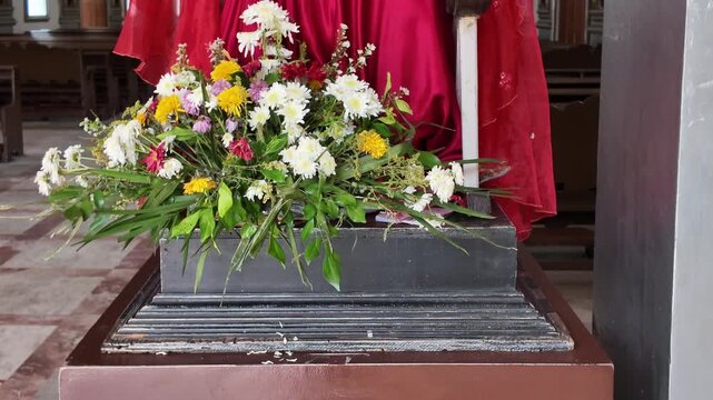 Flower arrangement at the feet of Jesus on church altar, Dumaguete, Philippines