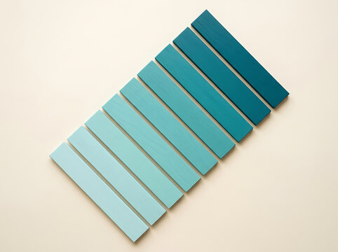 Gradient of rectangular teal and blue paper swatches on beige