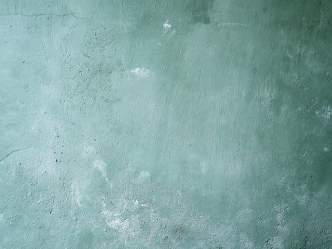 Textured greenish-blue wall with cracks and patches