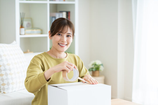 家で荷造りをする若い女性