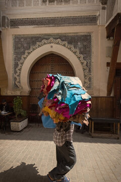 Man carrying the bunch of colored furs from the tannery in Fes old town Morocco