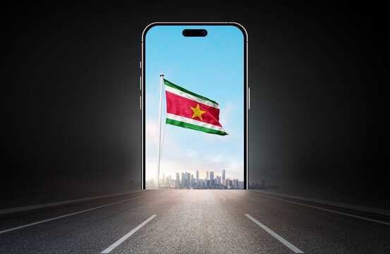 Suriname national flag on phone screen over highway to city. Suriname flag for Republic Day and Independence Day.