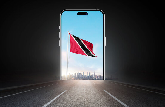 Trinidad and Tobago national flag on phone screen over highway to city. Trinidad and Tobago flag for Republic Day and Independence Day.