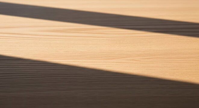 Warm sunlight casting diagonal shadows on natural wood grain surface
