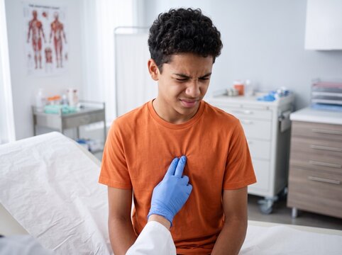 Teenage boy with costochondritis experiencing severe chest pain during medical examination, 
doctor pressing on inflamed ribs with gloved hand