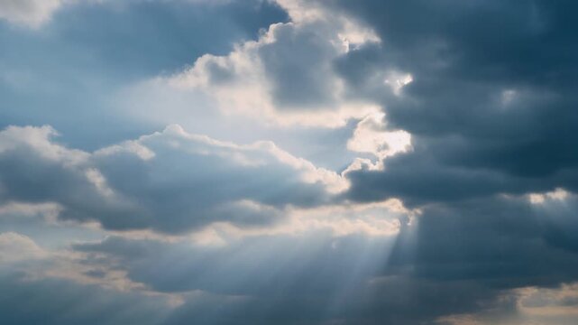 Beautiful sun rays shining through dramatic clouds in the sky