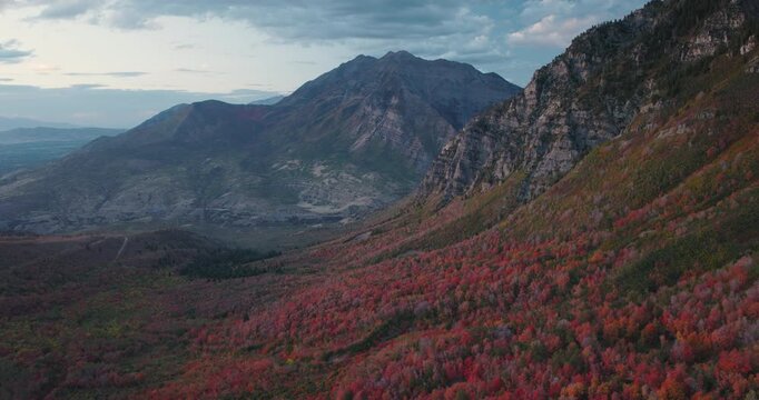 Majestic Wide View Over Autumn Colors In Rocky Mountain Canyon Of Utah - Lowering Drone Shot At Dusk