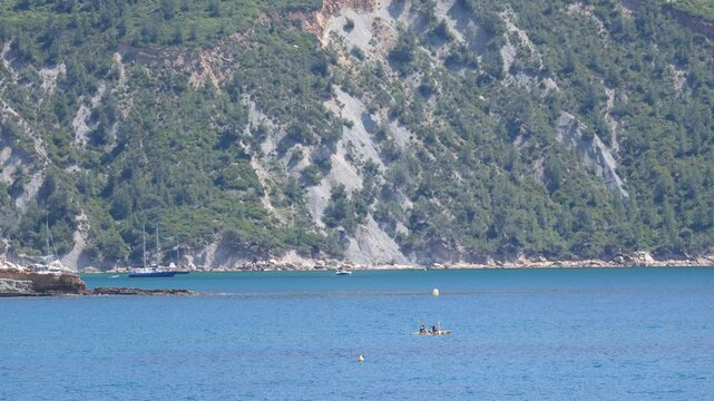 Kayakers Rowing Across Calm Sea Near Coastal Cliffs in Cassis France