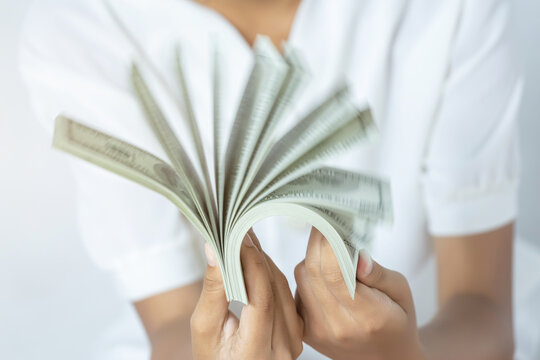 US dollars. Hand counting one hundred american money or 100 USD domination note.