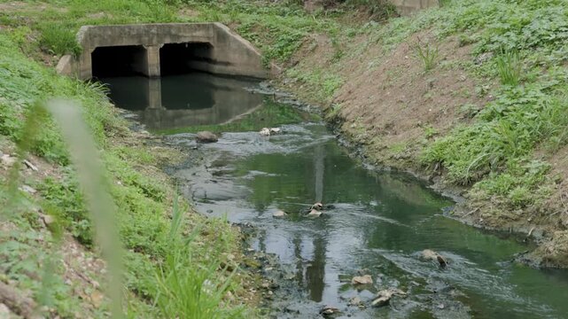 Shallow polluted river with sediment buildup and wastewater discharge, illustrating water contamination, sewage pollution, environmental degradation, ecosystem damage and water management.