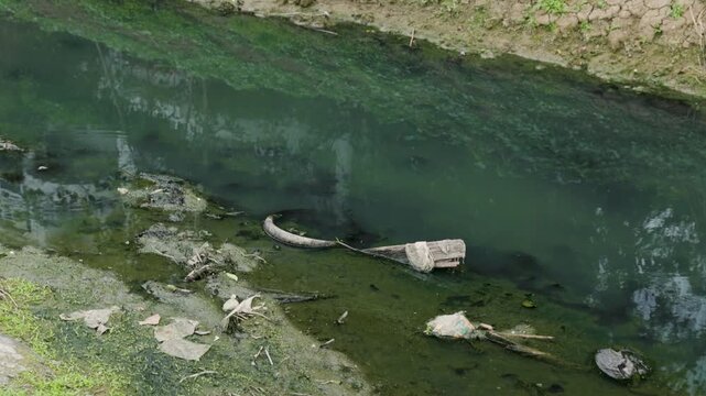 Shallow polluted river with sediment buildup and wastewater discharge, illustrating water contamination, sewage pollution, environmental degradation, ecosystem damage and water management.