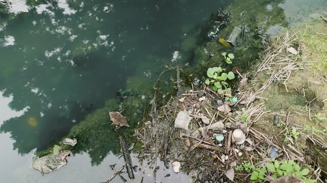 Polluted shallow river with sediment and wastewater discharge, symbolizing human impact, environmental destruction, ecosystem degradation, water contamination.
