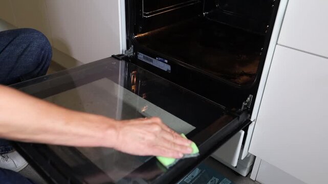 Stockholm, Sweden A woman performs a deep clean on an oven and stovetop. 