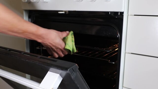 Stockholm, Sweden A woman performs a deep clean on an oven and stovetop. 
