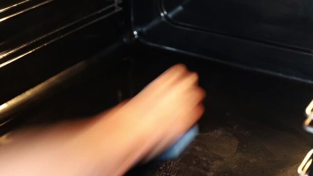 Stockholm, Sweden A woman performs a deep clean on an oven and stovetop. 