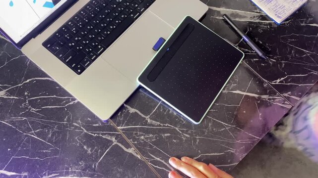 Person drawing on tablet, overhead view, then leaving the desk after a digital illustration session, showing freelance workflow, remote work routine and graphics production