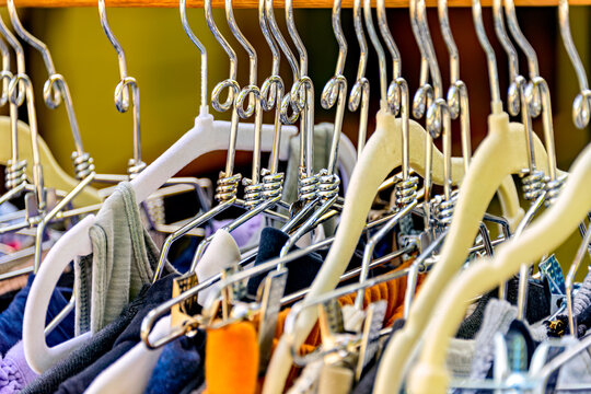 Row of clothes hanging on metal and plastic hangers