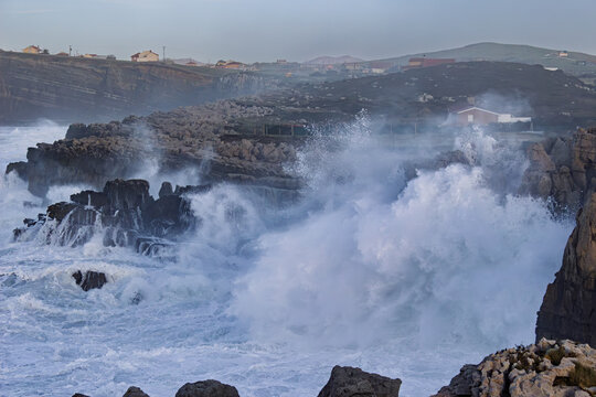 Powerful Storm Wave Exploding Into Sea Spray Against Rocky Coast at Dusk in Cuch&iacute;a, Cantabria, Spain