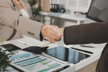 Business people shaking hands finishing up a meeting. Two confident businessman shaking hands during a meeting in the office, success, dealing, greeting and partner concept. © Natchanida