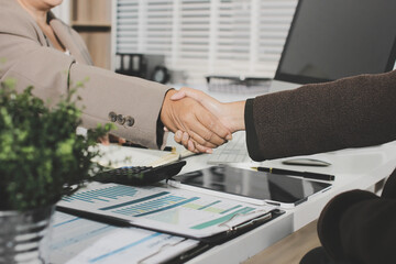 Business people shaking hands finishing up a meeting. Two confident businessman shaking hands during a meeting in the office, success, dealing, greeting and partner concept. © Natchanida
