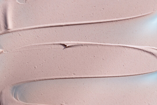 Beige liquid foundation smear, concealer texture smudge. Make up base drops, cream textured background. Closeup macro. Cosmetic tonal makeup moisturizer, bb cream swatch