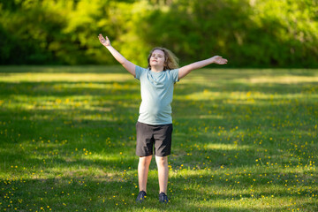 Obraz premium Child enjoys mindful breathing outdoors. Child feels calm in meadow. Happy child shows joyful freedom. Peaceful child relaxes in sunshine.
