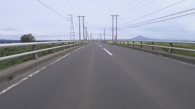 青森県の真っすぐ伸びるコメ米ロードと岩木山