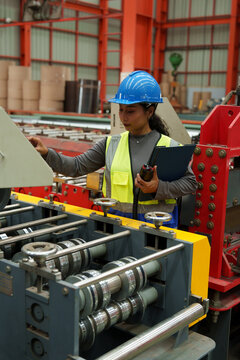 Engineers and staff are inspecting the assembly line system in a metal sheet and metal roofing manufacturing plant.	