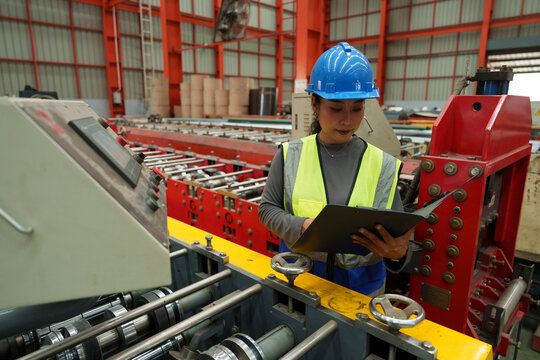 Engineers and staff are inspecting the assembly line system in a metal sheet and metal roofing manufacturing plant.	