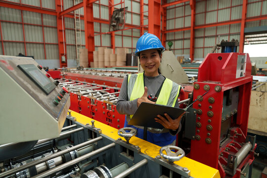Engineers and staff are inspecting the assembly line system in a metal sheet and metal roofing manufacturing plant.	