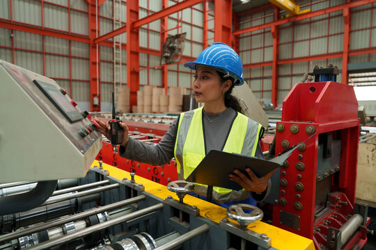 Engineers and staff are inspecting the assembly line system in a metal sheet and metal roofing manufacturing plant.	