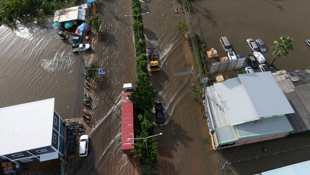 An elevated view of a flooded road with vehicles driving through the water.	