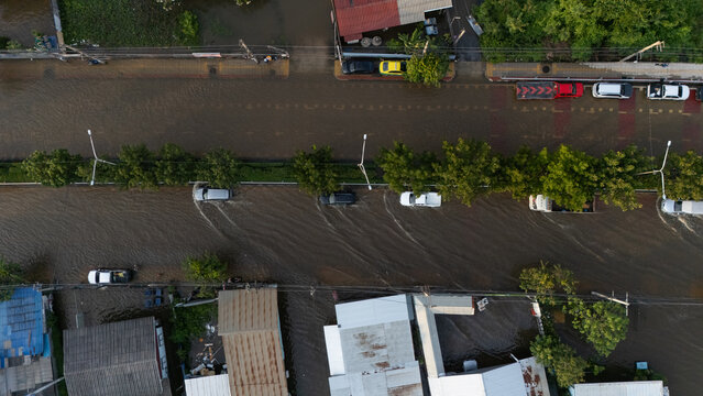 An elevated view of a flooded road with vehicles driving through the water.	