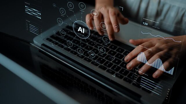 Hands type on a laptop. Learning, content and research functions connect through an AI hub, with monitoring providing visibility into resources and the movement of information.