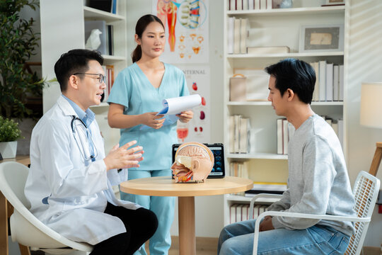 Neurologist explaining brain scan results and conducting physical movement response test with patient in medical clinic,representing healthcare,neurology diagnosis,Health care and technology.