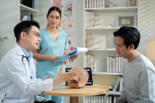Neurologist explaining brain scan results and conducting physical movement response test with patient in medical clinic,representing healthcare,neurology diagnosis,Health care and technology.