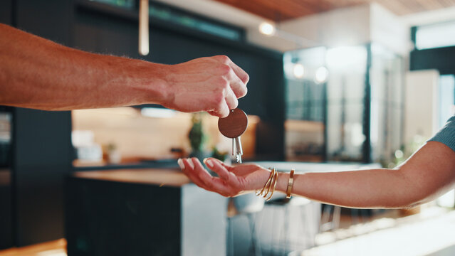 Hands, key and landlord in new house with tenant, property investment or rental agreement with owner. People, keychain handover and moving in apartment with housing agent, relocation and real estate
