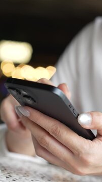 woman holds smart phone in her hands and scrolls through the news feed. Close up of hand uses mobile. point finger on screen, texting text message.