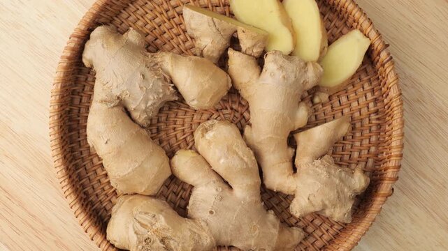 Fresh ginger root and slices rotating in a wicker basket