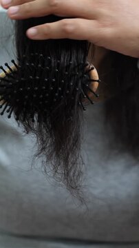 woman sticking brushing her hair falling out and have many hair loss on the comb. problem of Damaged and frizzy. Healthcare and medical concept.	
